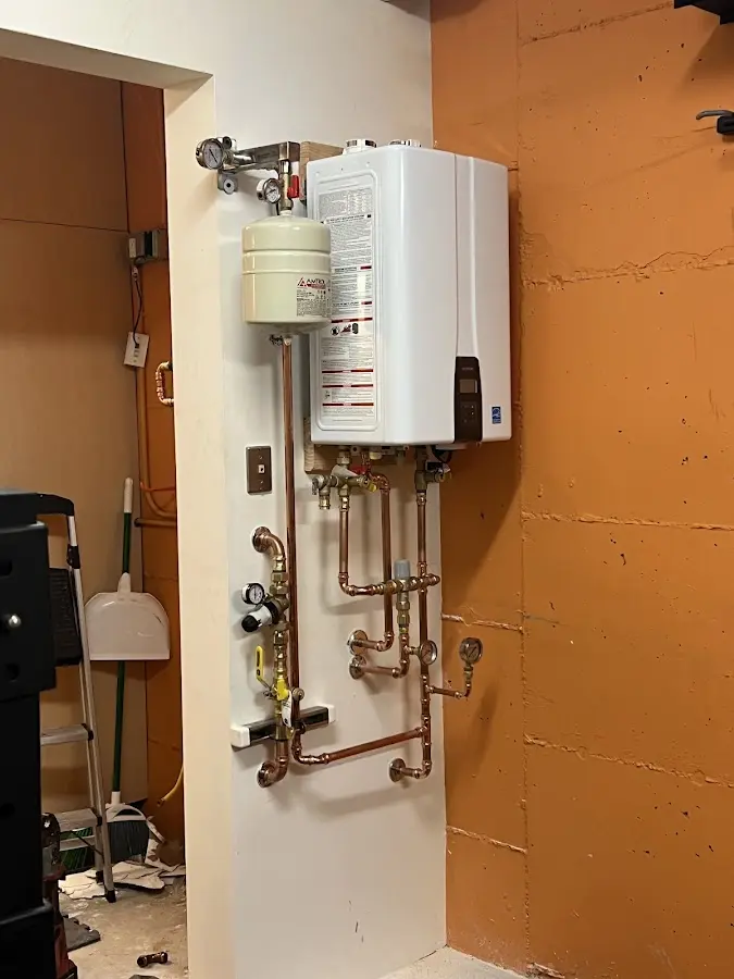 Plumbing technician inspecting water heater connections in River Forest